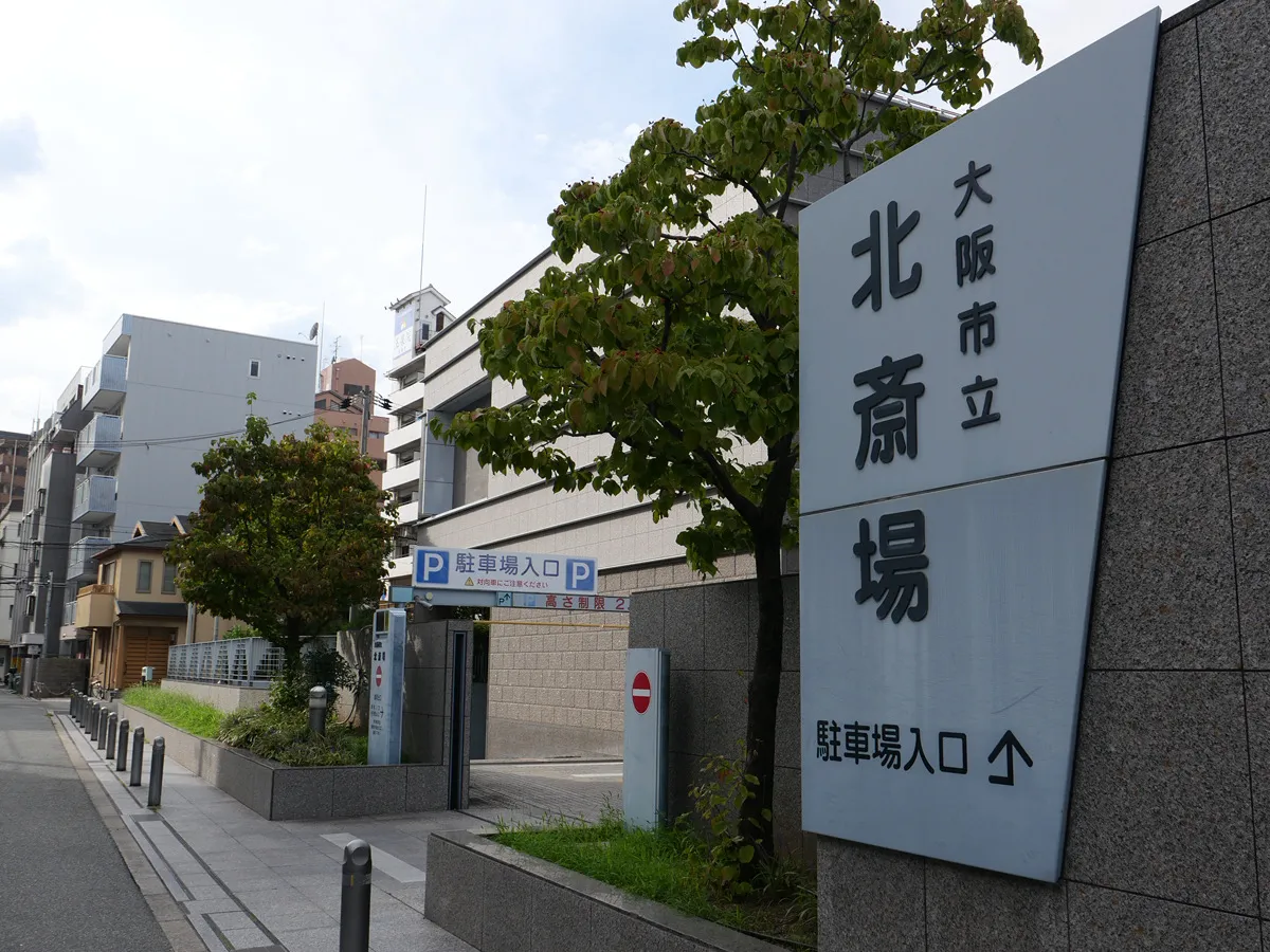 北斎場の前の道路。「大阪市立北斎場 駐車場入口」の大きな看板が立っている